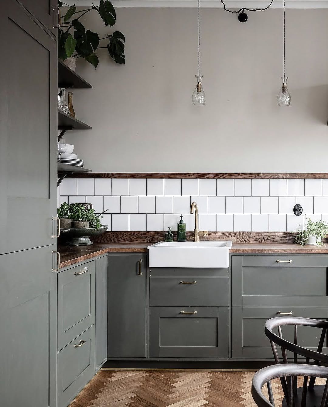 Green-toned kitchen with custom cabinetry, updated lighting, and modern finishes after completing a full home remodeling service